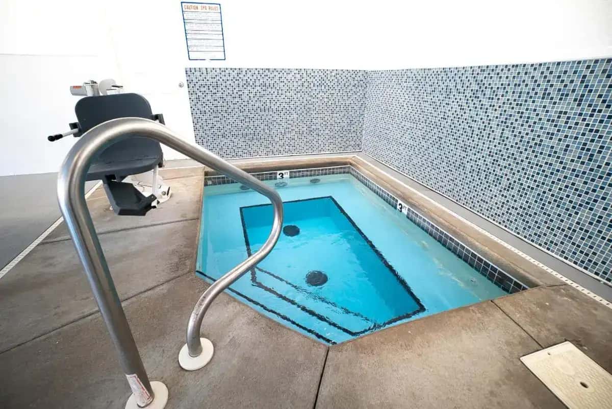 a jacuzzi tub with a chair in a bathroom at The Stone Castle Hotel & Conference Center in Branson