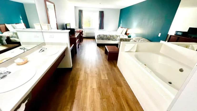 a bathroom with two sinks and a bath tub at Studio 6 Suites Portland OR I-5 OHSU in Portland