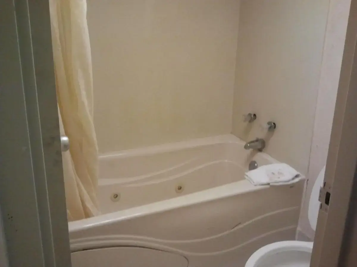 a bathroom with a tub and a toilet at Studio 9 Inn & Suites in Decatur