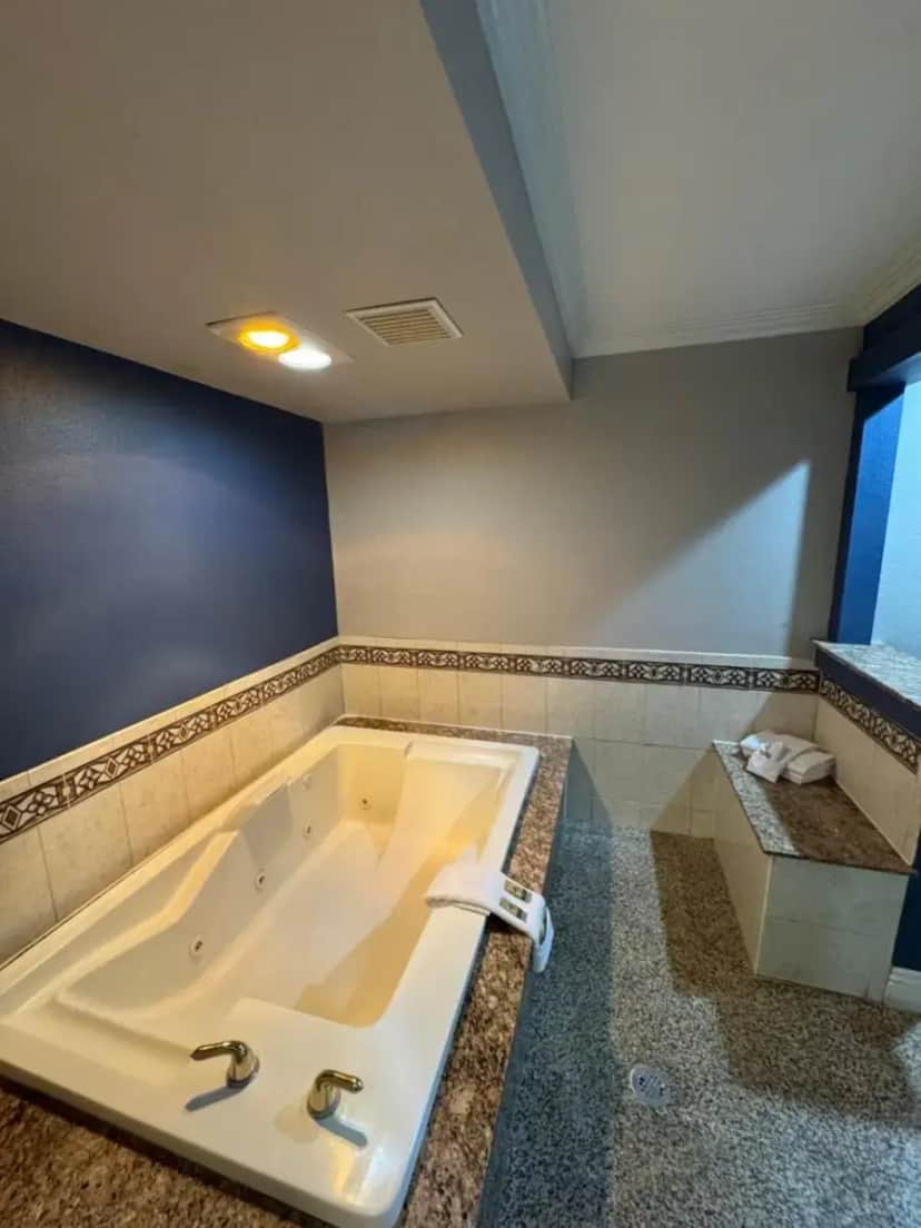 a large bath tub in a bathroom with a sink at Sunset Inn & Suites in Gardena