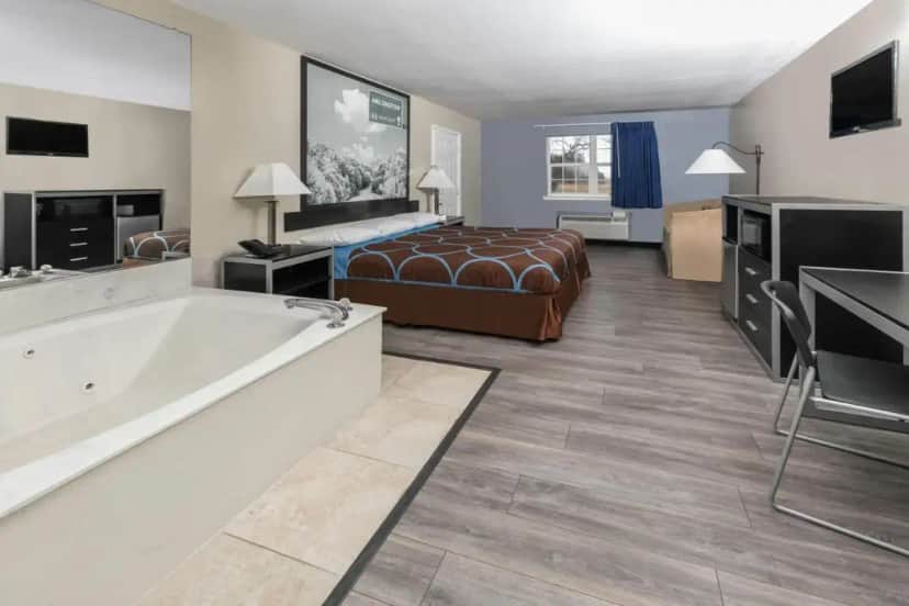 a hotel room with a bed and a bath tub at Super 8 by Wyndham Arlington Near AT&T Stadium in Arlington