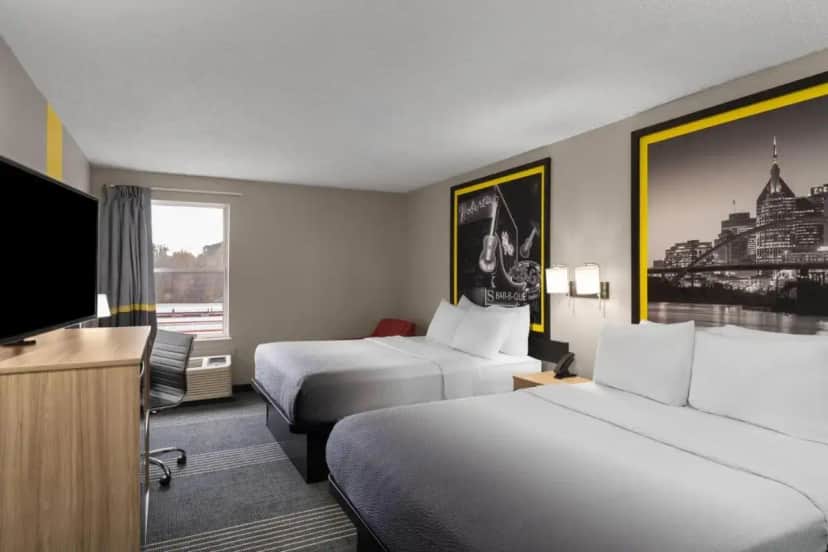 a hotel room with two beds and a flat screen tv at Super 8 by Wyndham Chattanooga East - Hamilton Place in Tyner
