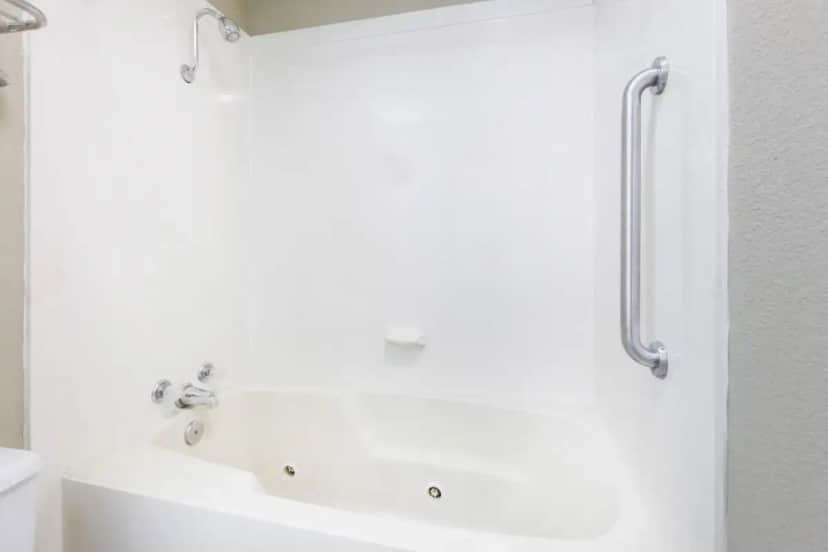 a white bath tub in a white bathroom at Super 8 by Wyndham Harrison AR in Harrison