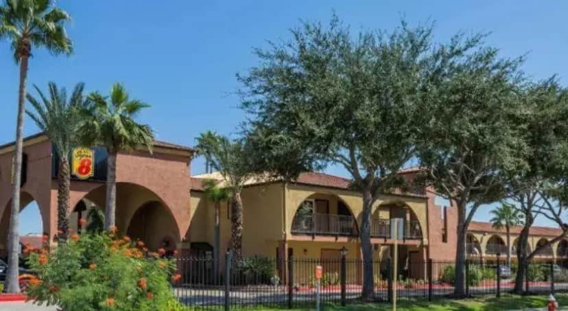 a building with trees and a fence in front of it at Super 8 By Wyndham Houston/Nasa/Webster Area in Webster