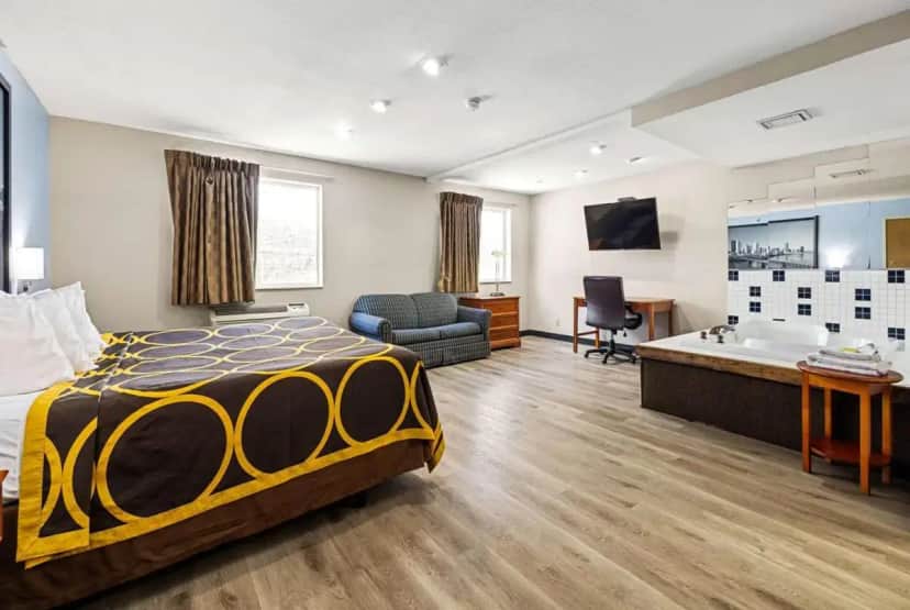 a hotel room with a bed and a bathroom at Super 8 by Wyndham Pittsburgh/Monroeville in Monroeville
