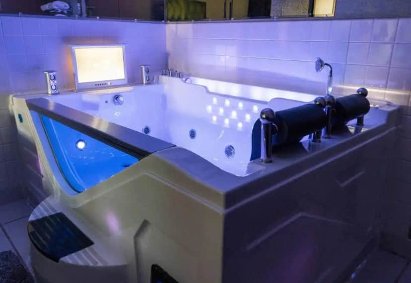 a bath tub in a bathroom with a blue tub at Super 8 by Wyndham Uniontown PA in Uniontown