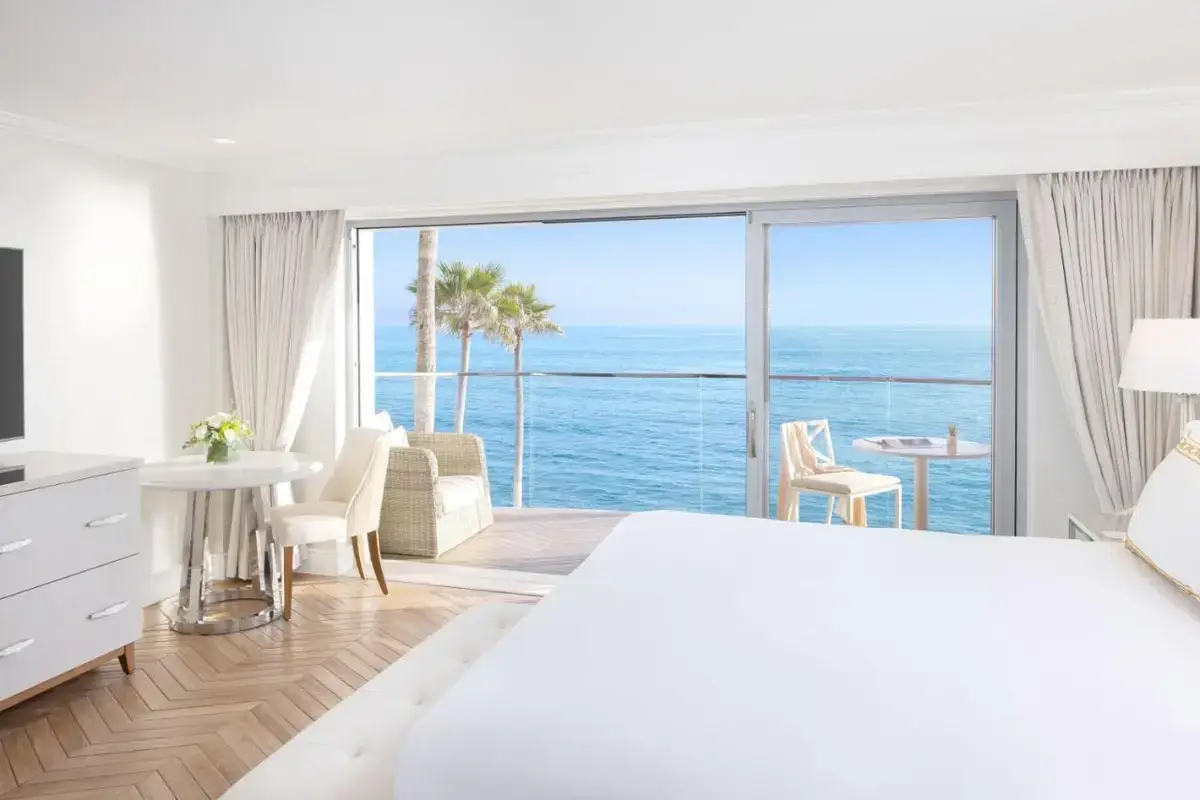 a bedroom with a bed and a view of the ocean at Surf & Sand Laguna Beach in Laguna Beach