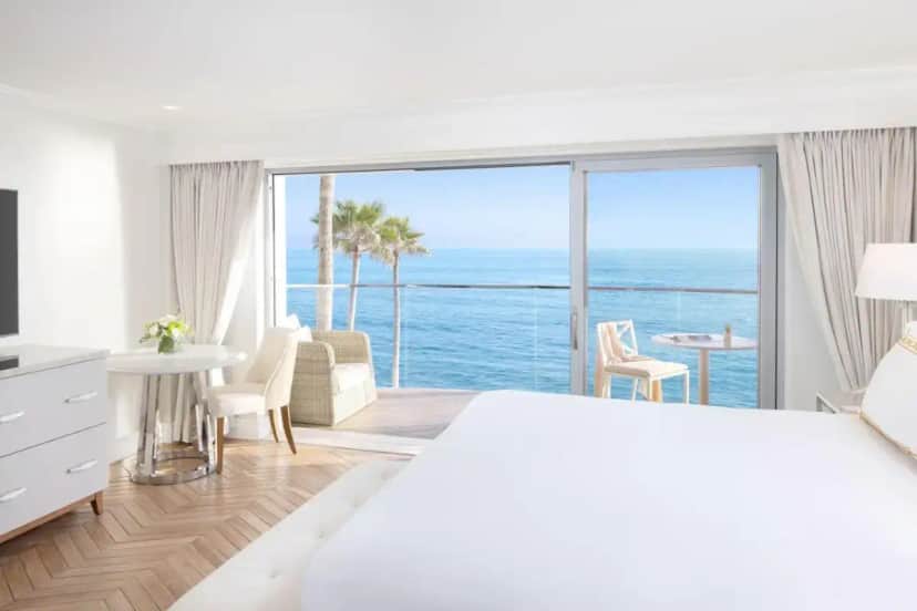 a bedroom with a bed and a view of the ocean at Surf & Sand Laguna Beach in Laguna Beach
