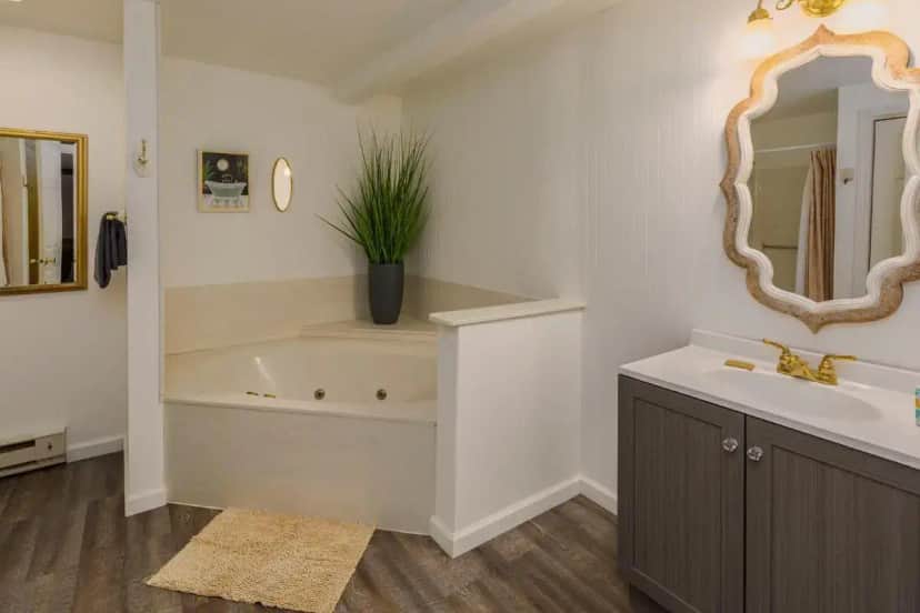 a bathroom with a tub and a sink and a mirror at Sweetgrass Inn Bed & Breakfast in Rapid City