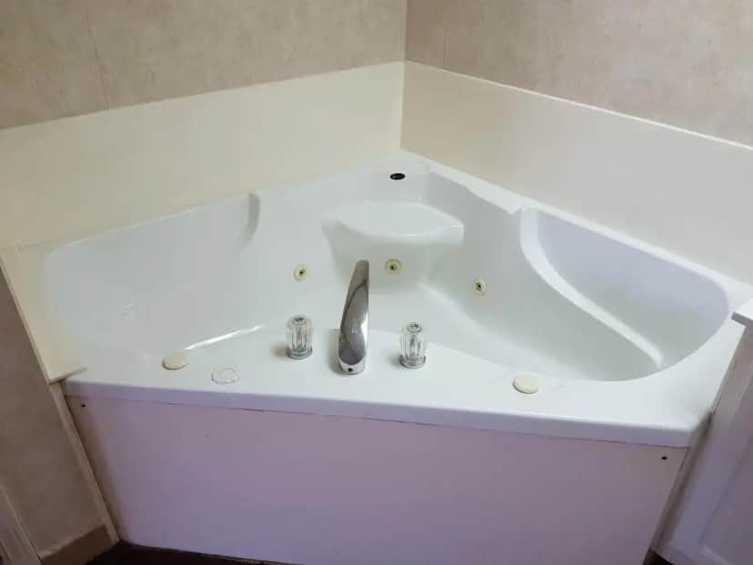 a white bath tub with a sink and a faucet at Swiss Village Inn in Eureka Springs