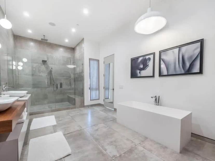 a bathroom with a tub and a shower and a sink at Sycamore Villa in Los Angeles