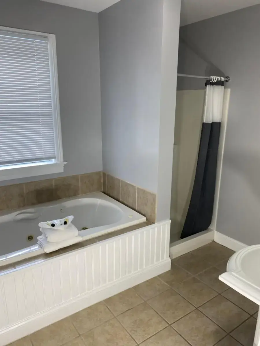 a bathroom with a tub and a sink and a toilet at Taber Inn in Mystic