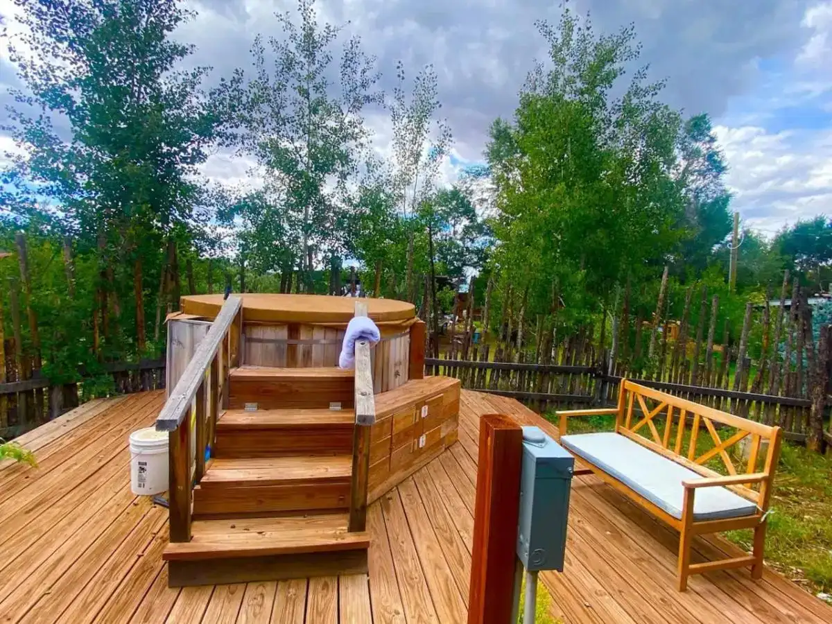 a deck with a hot tub and a chair at Taos Goji Farm & Eco-Lodge Retreat in Arroyo Seco