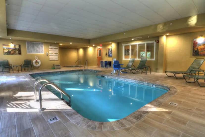 a pool in a hotel room with chairs and tables at The Appy Lodge in Gatlinburg