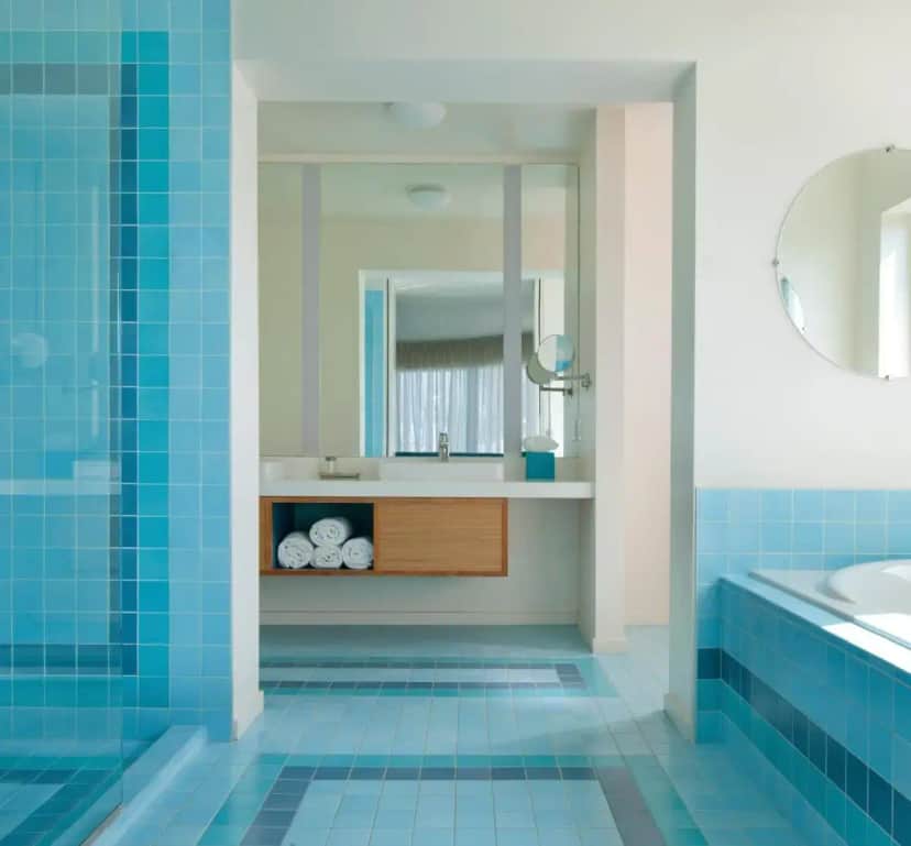 a bathroom with blue tiles and a sink and a mirror at The Beverly Laurel Hotel at West Hollywood in Los Angeles