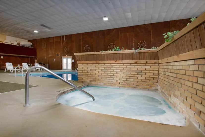 a hot tub in a room with a brick wall at Carriage House Country Club in Pocono Manor