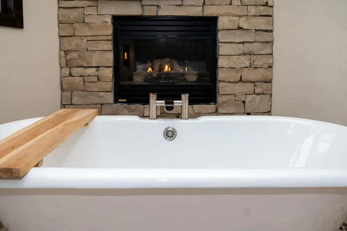a white bath tub in front of a fireplace at The Estes Park Resort in Estes Park