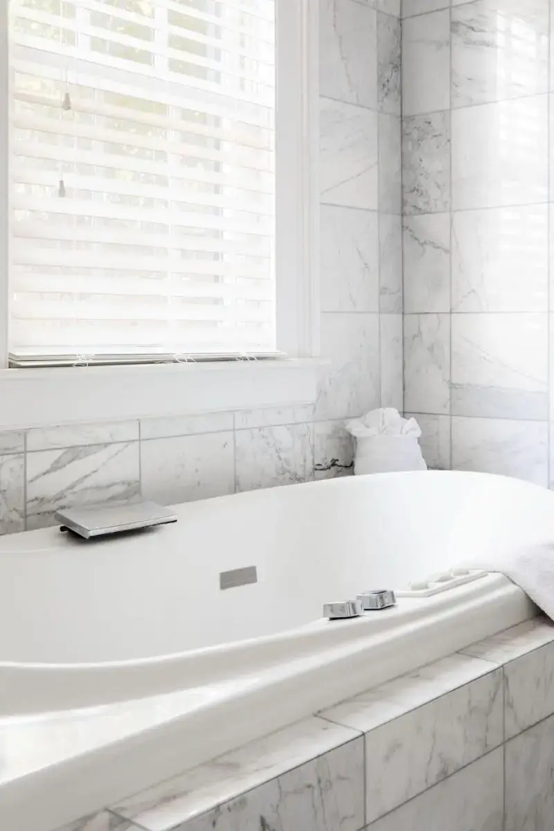 a white bath tub in a bathroom with a window at The Gardens Hotel in Key West