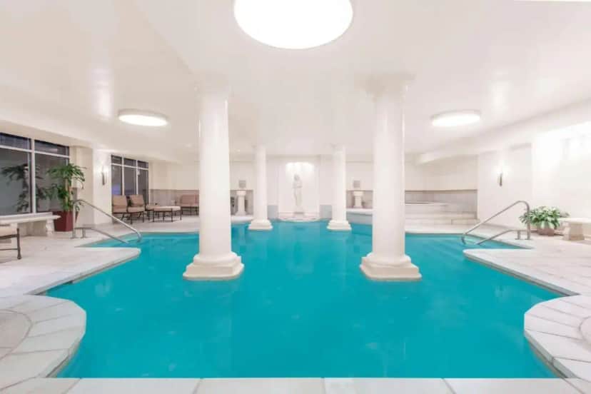 a large pool with blue water in a building at The George Washington - A Wyndham Grand Hotel in Winchester