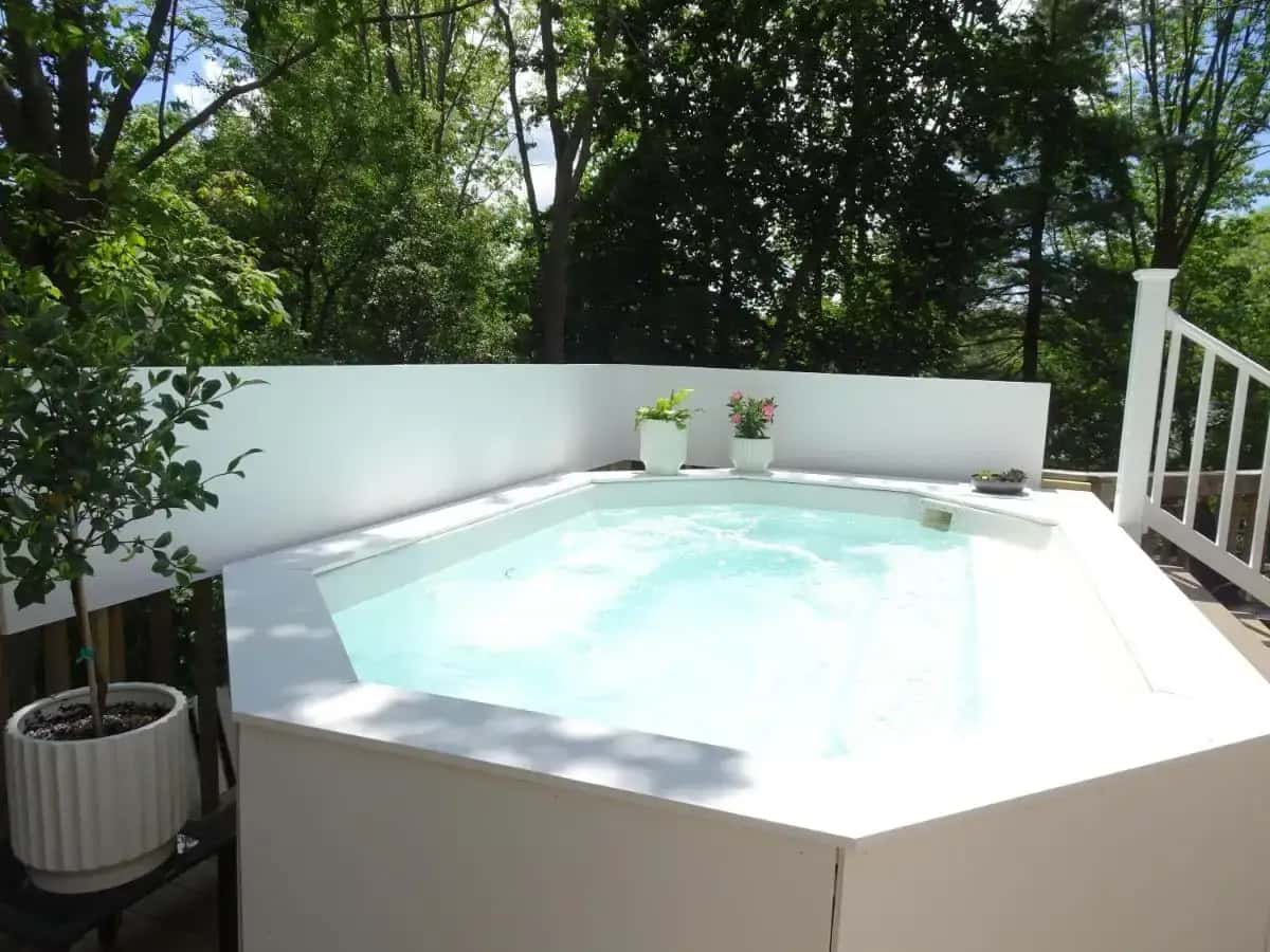 a hot tub on a patio with trees at The Grand Hotel in Ogunquit