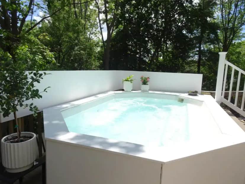 a hot tub on a patio with trees at The Grand Hotel in Ogunquit