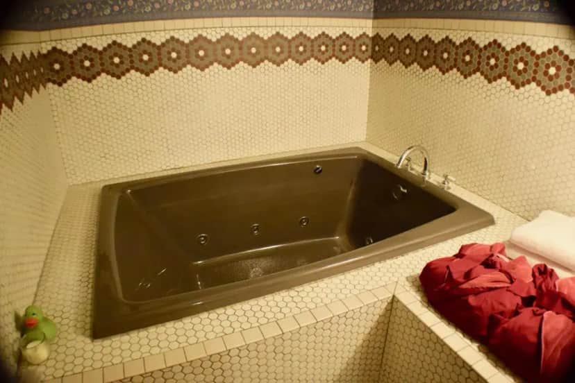 a bathroom with a black tub in the corner at The Hancock House Bed & Breakfast Inn in Dubuque