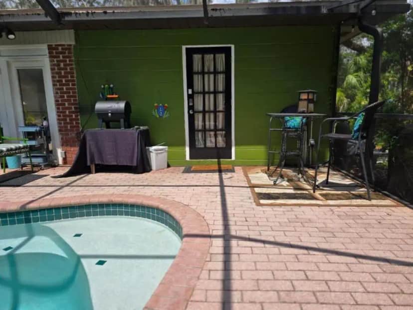 a green house with a swimming pool in front of it at The Jungle Oasis by Busch Gardens, USF, and Amphitheater in Tampa