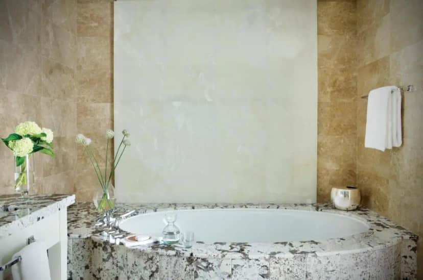 a bathroom with a bath tub with a vase of flowers at The Langham Chicago in Chicago