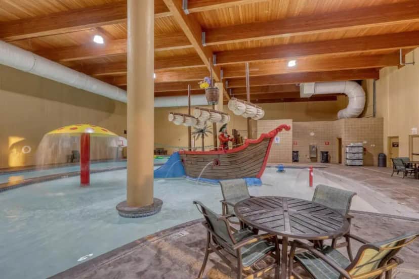 a large indoor pool with a table and chairs at The Lodge at Deadwood in Deadwood