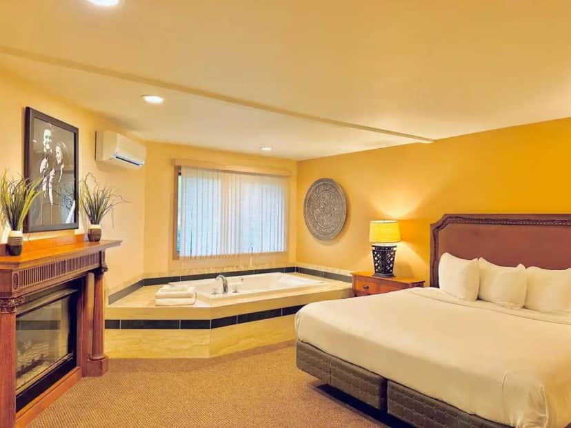 a bedroom with a bed and a bath tub at The Lodge at Leathem Smith in Sturgeon Bay