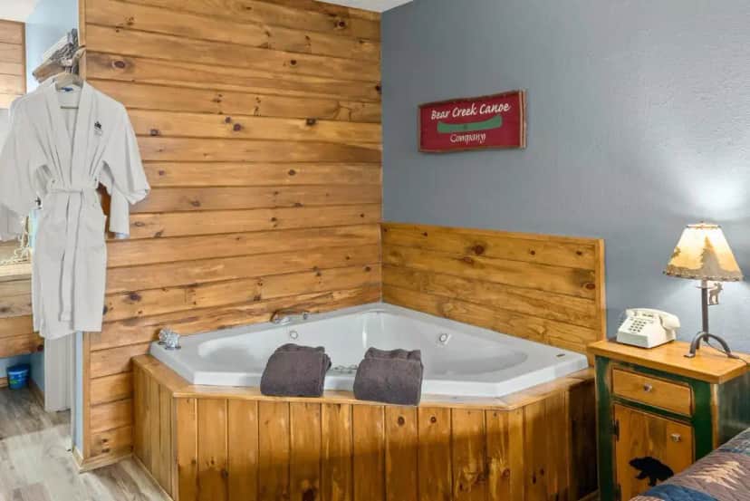 a bath tub in a room with a wooden wall at The Lookout Lodge in Eureka Springs