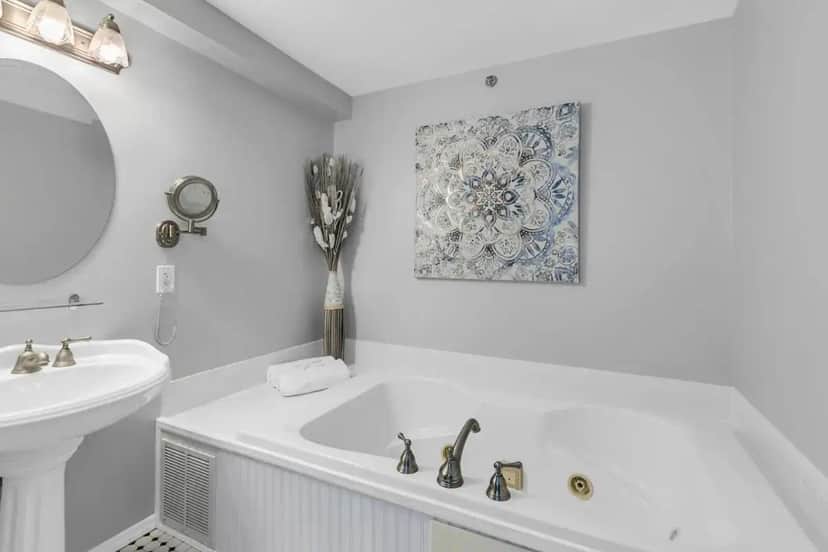 a white bathroom with a tub and a sink at The Opal & Pearl in Belmar