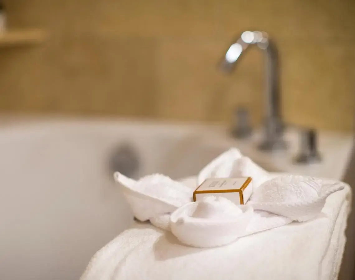 a white towel with a gold bar on top of a bath tub at The Paramount Hotel in Seattle