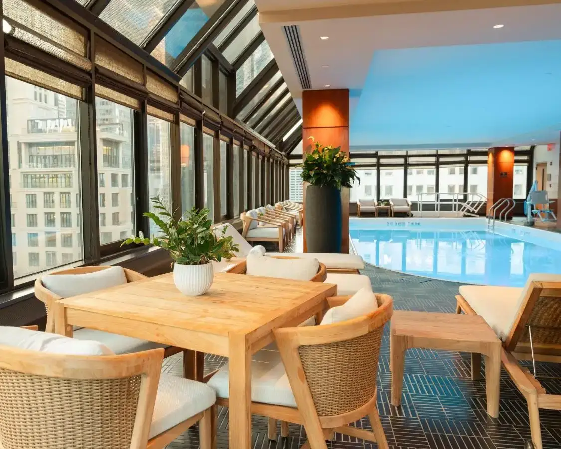 a restaurant with a pool and tables and chairs at The Peninsula New York in New York