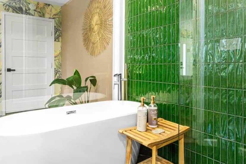 a bathroom with a tub and a green tiled wall at The Railyard NOLA - Adult Only, Clothing Optional Pool in New Orleans