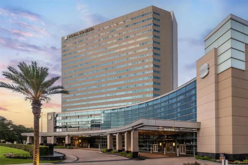 a tall building with a palm tree in front of it at The Royal Sonesta Houston Galleria in Houston