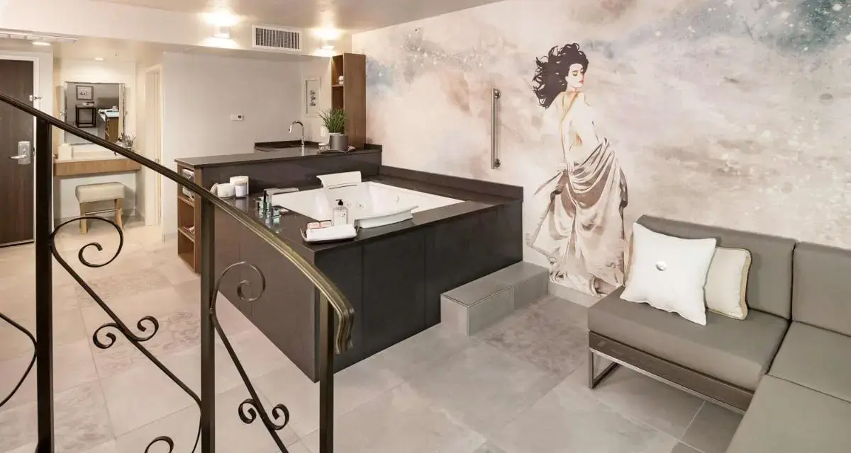 a bathroom with a painting of a woman on the wall at The Rushmore Hotel & Suites; BW Premier Collection in Rapid City