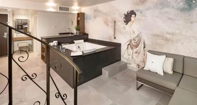 a bathroom with a painting of a woman on the wall at The Rushmore Hotel & Suites; BW Premier Collection in Rapid City