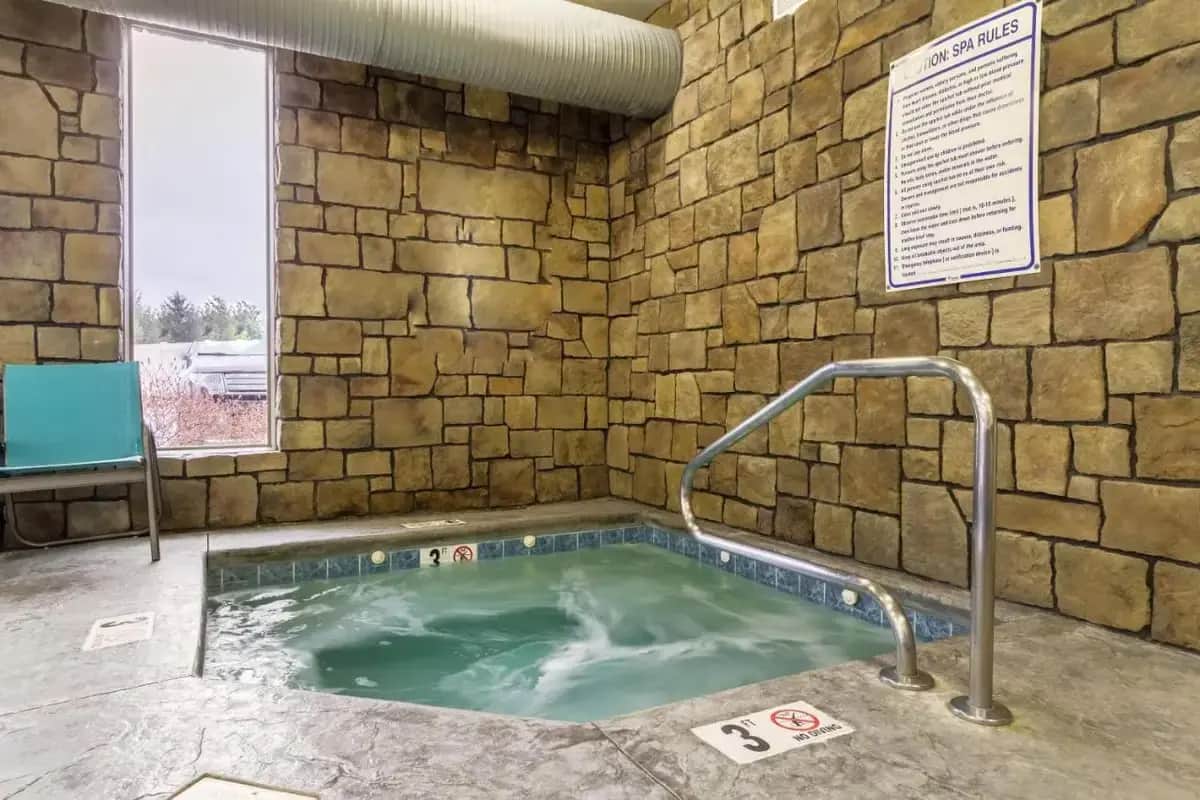 a hot tub in a room with a stone wall at The Wallhouse Hotel, an Ascend Collection Hotel in Walnut Creek