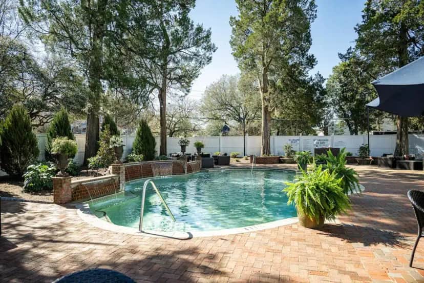 a swimming pool in a yard with trees at The Willcox in Aiken
