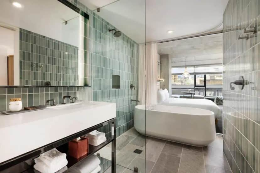 a bathroom with a tub and a sink and a bed at Timbri Hotel San Francisco, Curio Collection by Hilton in San Francisco