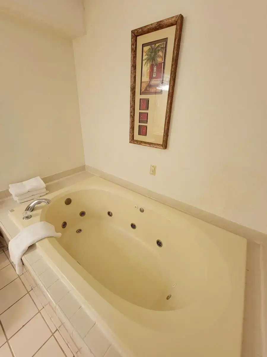 a bath tub in a bathroom with a picture on the wall at Town Inn in Bordentown