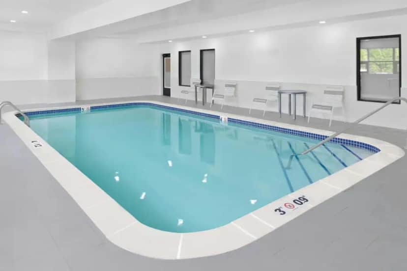 a large swimming pool with blue water in a building at TownePlace Suites Detroit Warren in Warren
