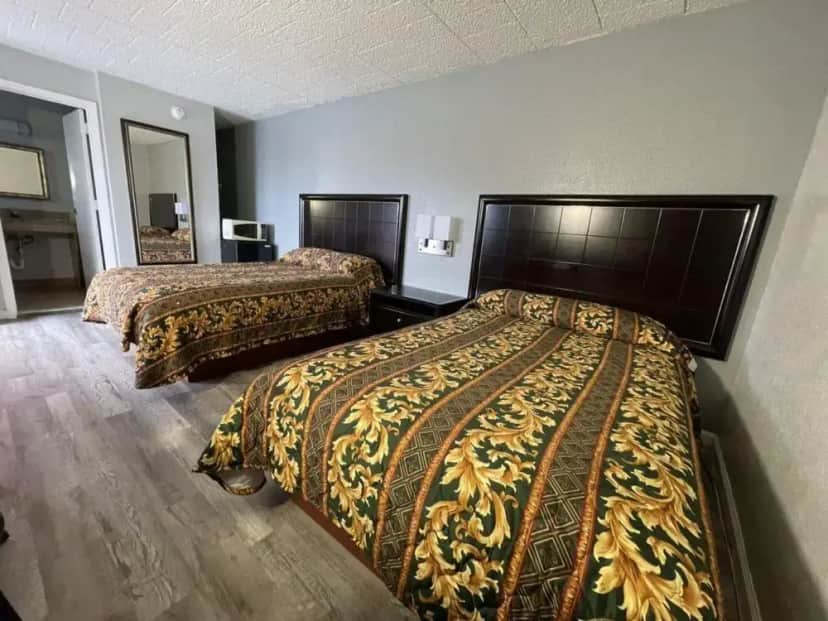 a hotel room with two beds and a mirror at Towson East Motel in Towson