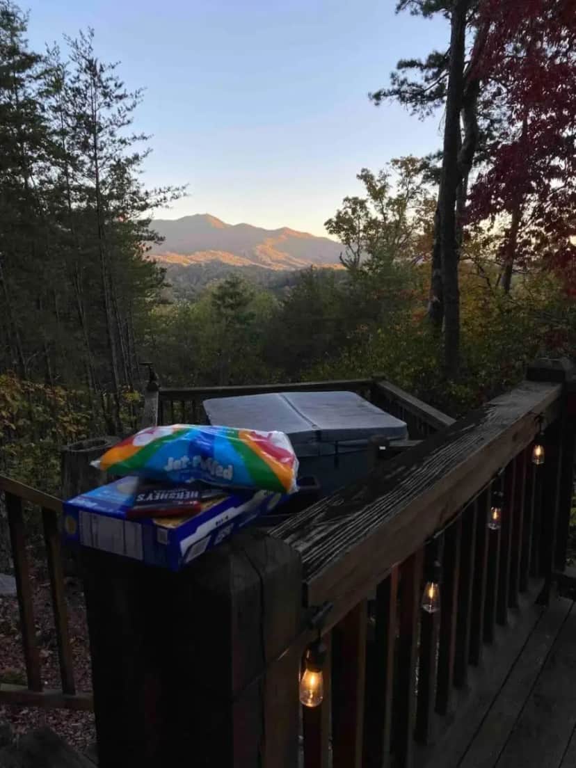 a blanket is sitting on a wooden railing on a deck at Turkey Ridge Retreat in Bryson City