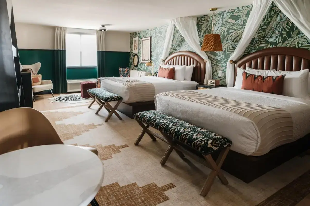 a hotel room with two beds and a chair at UNCOMMONER HOTEL by Reverie Boutique Collection in West Yarmouth