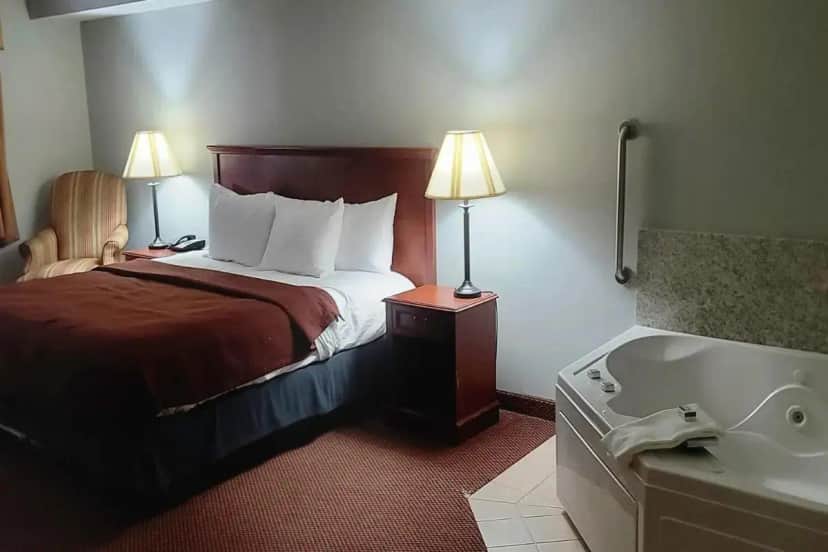 a hotel room with a bed and a bath tub at University Inn in Boiling Springs