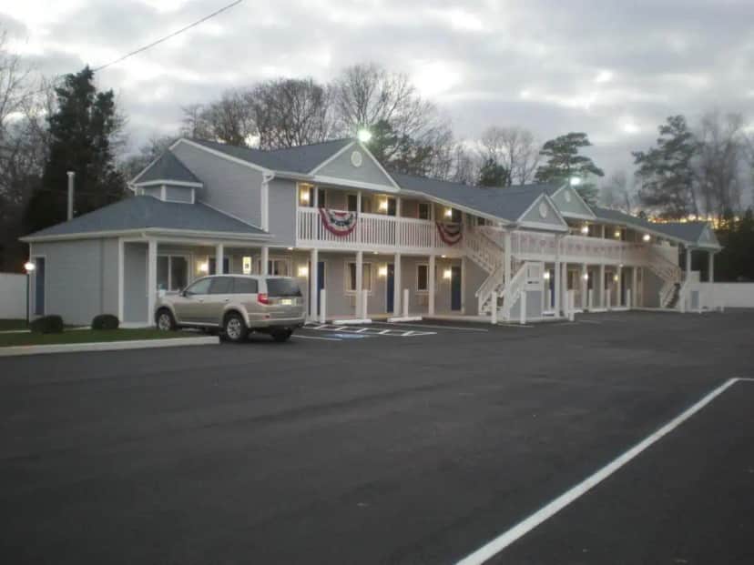a house with a car parked in front of it at Village Inn & Suites - Smithville in Smithville