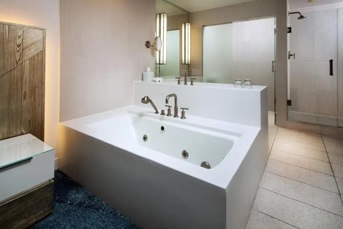 a white bathroom with a tub and a sink at W Fort Lauderdale in Fort Lauderdale