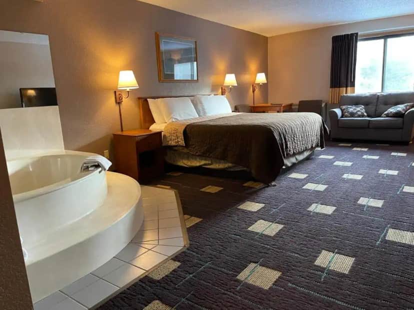 a hotel room with a bed and a bath tub at Walker Hotel in Walker